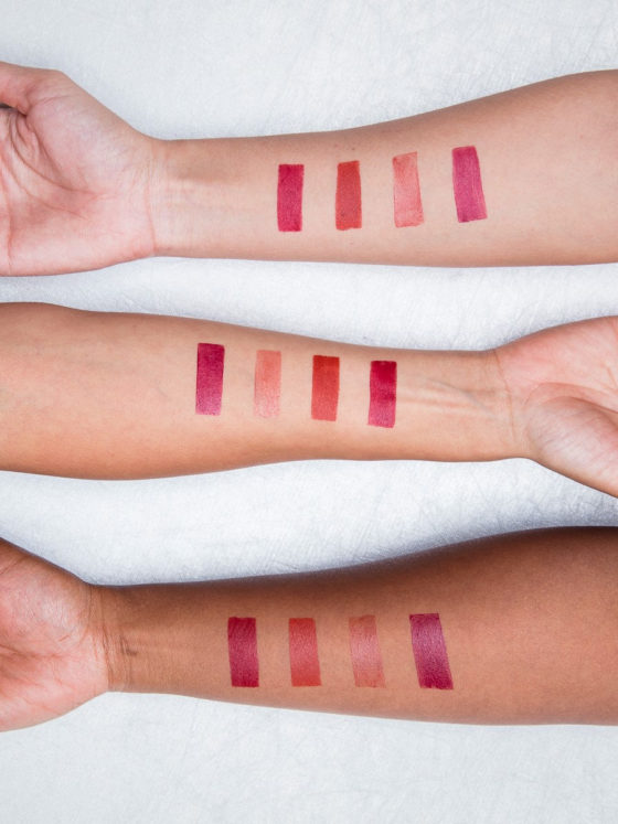 Three arms laid one above the other, with lipstick test strips in various different shades of pink. The image is there to signify clean beauty and how it is better for your skin.